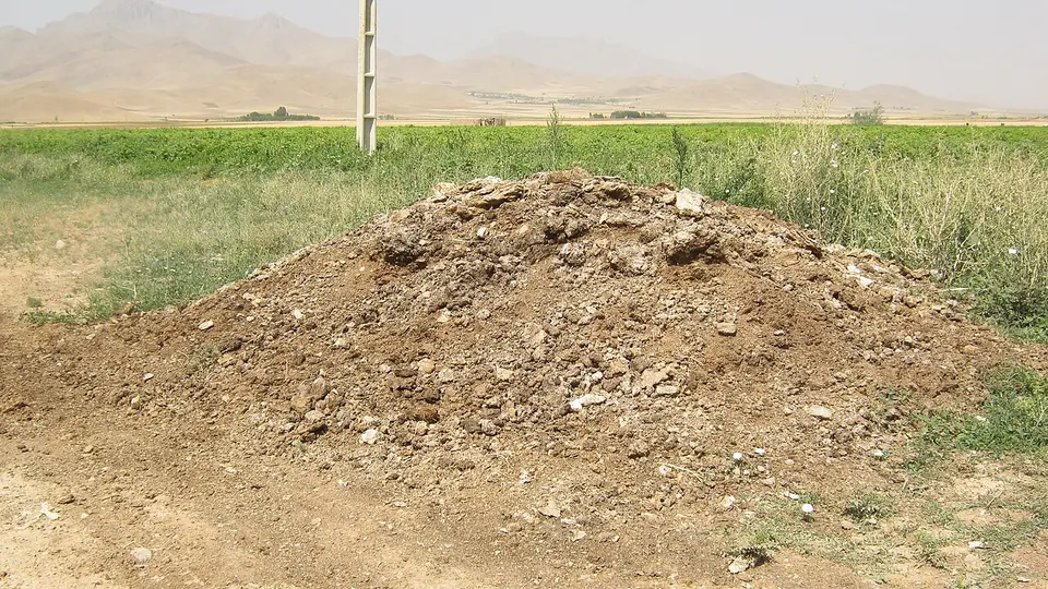 Pilha de esterco curtido amontoada na beira da área de cultivo