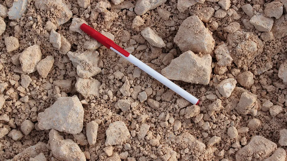 Pedras de calcário britado cobrindo o chão, com uma caneta apoiada como escala