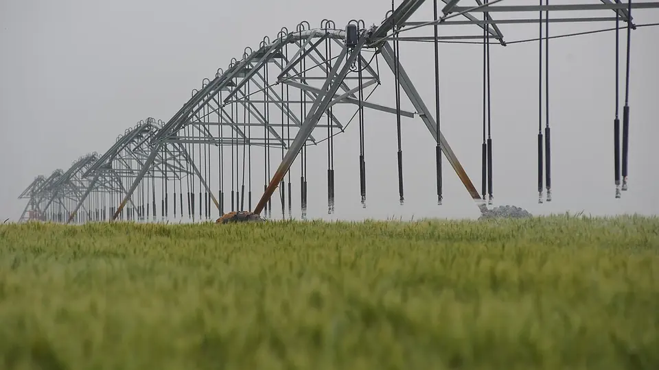 Estrutura de pivô central montada sobre lavoura verde no campo