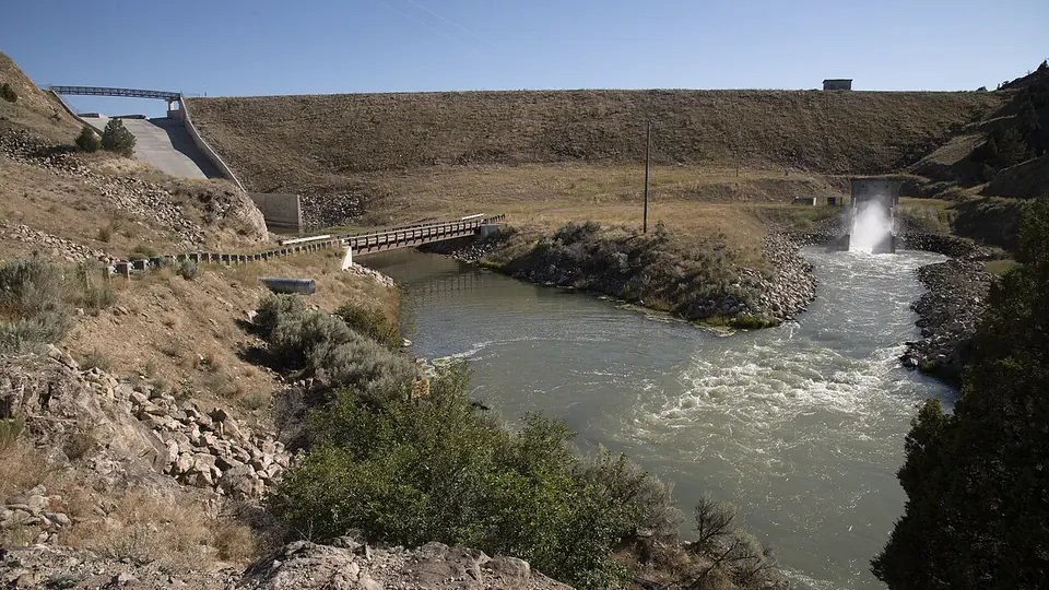 Canal de irrigação em terra com água corrente e barrancos de solo exposto