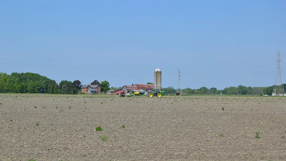 Talhão de solo exposto no início da safra com a sede da fazenda ao fundo