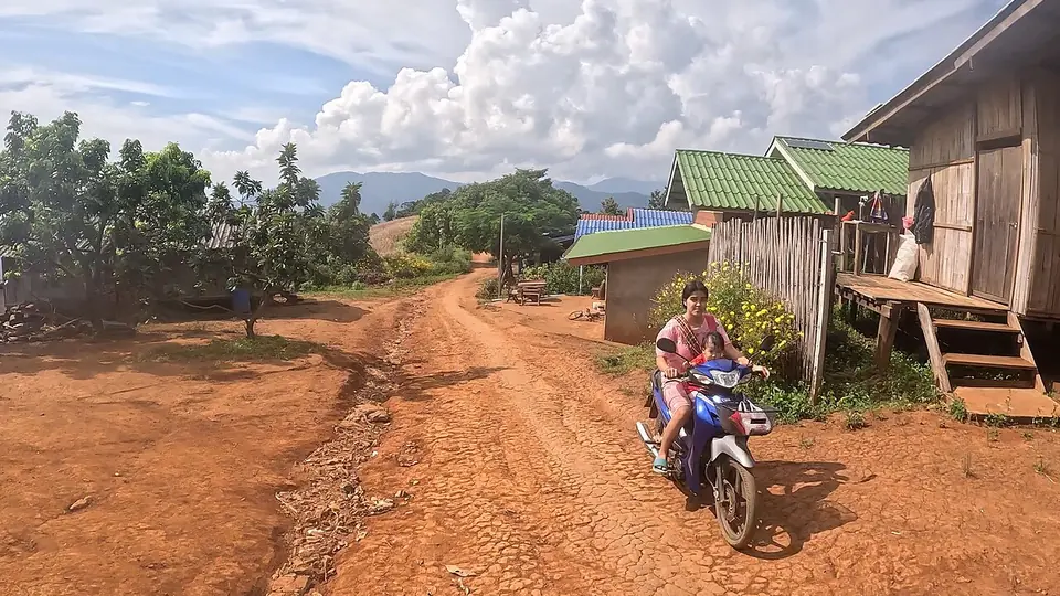 Estrada de terra vermelha com solo exposto e rachado em área rural